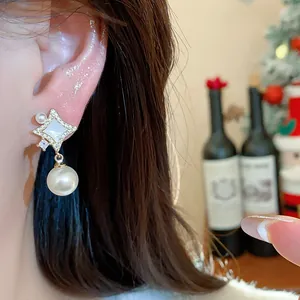 Detailed view of elegant 14K gold plated star earring with pearl drop and zircon accents