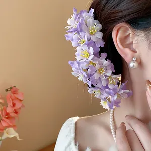 Detailansicht einer süßen Stoff-Haarnadel mit lila Blüten an einem asiatischen Model