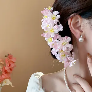 Seitenansicht von rosa Stoff-Haarnadeln mit Kirschblüten in einer süßen Hochsteckfrisur