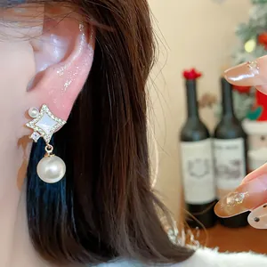 Close-up of elegant 14K gold plated star earring featuring sparkling zircons and a pearl drop