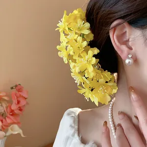 Eleganter Haarnadel aus gelbem Stoff mit Blumenmuster, getragen von einem Model für Hochzeiten