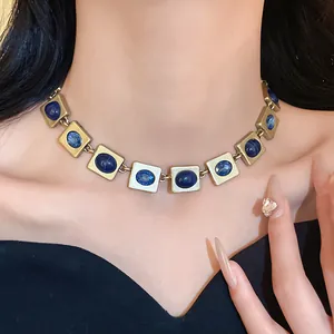 Gros plan d'un collier vintage en bronze avec gemmes bleues sur le cou d'un modèle