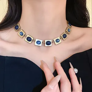 Collier vintage doré avec pierres bleues ovales porté par un mannequin élégant