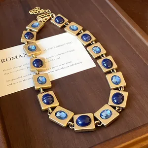Détail du collier vintage doré avec des pierres bleues et des cristaux à facettes