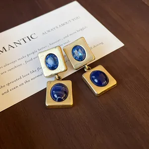 Gros plan détaillé de boucles d'oreilles vintage en or avec des pierres bleues
