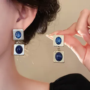 Gros plan détaillé de boucles d'oreilles vintage avec cristaux bleus et fini mat.