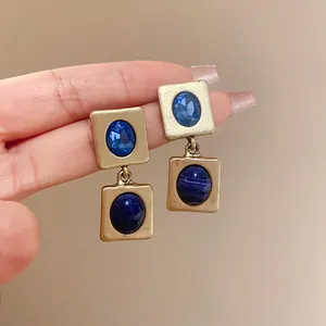 Gros plan de boucles d'oreilles vintage dorées avec pierres bleues de style palais.