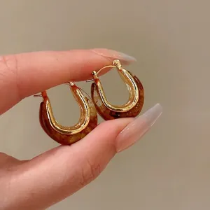 Vintage U-shaped geometric earrings with tortoise shell pattern and gold finish.