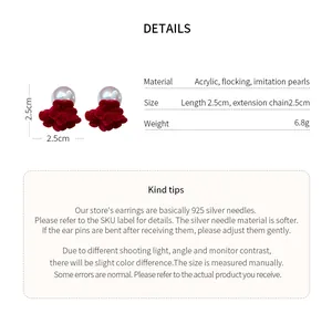 Detail of red flocked flower stud earrings with pearl accents and 925 silver needles.