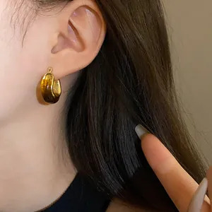 Detail of vintage U-shaped hoop earring with amber tortoiseshell resin and gold finish