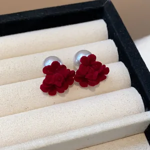 Close-up of red flocked flower earrings with silver pearls in a jewelry display box