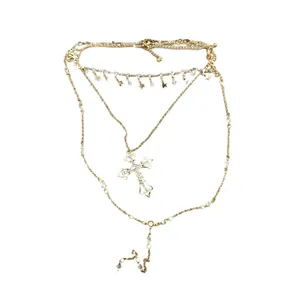 Multi-layer gold necklace featuring rhinestone cross and star pendants on white background