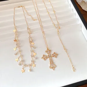 Detail view of gold-tone necklaces with rhinestone cross and star tassel charms