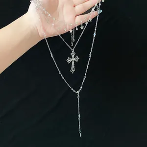 Detailed view of silver multi-layered necklace with rhinestone cross and star charms.