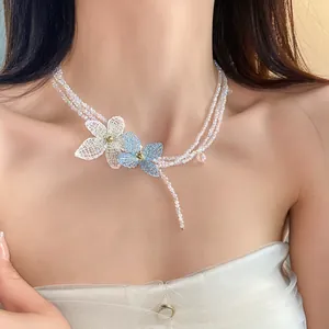 Primer plano de un elegante collar de cuentas de varias capas con flores de cristal.