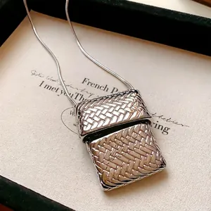 Elegante collana argentata con ciondolo a borsa intrecciata e design a catena a serpente
