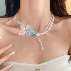 Detalle de un collar de cuentas de varias capas estilo coreano con elegantes flores de cristal.