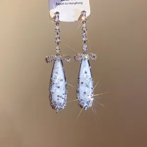Elegant silver drop earrings featuring zircon bowknots and white mother of pearl