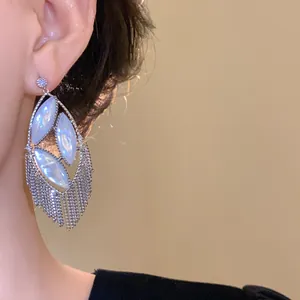 Detailed view of elegant silver tassel earrings with iridescent mother-of-pearl stones