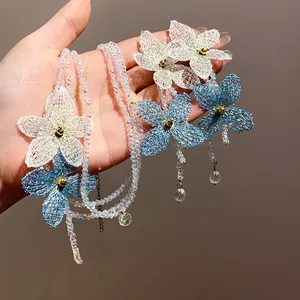 Detalle de collares de cuentas de vidrio multicapa con delicadas flores de malla hechas.