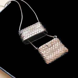 Vista macro dettagliata dei pendenti mini borsa intrecciati su una collana lunga a serpente