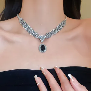 Close-up of sparkling silver choker necklace with a dark blue oval gemstone pendant