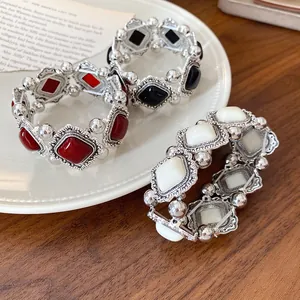 Three vintage acrylic diamond-shaped stretch bracelets in black, red, and white