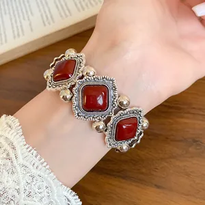 Detailed view of vintage palace style elastic bracelet with red acrylic stones and silver frame