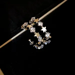 Dettaglio macro di eleganti orecchini a forma di C in argento con stelle di zircone