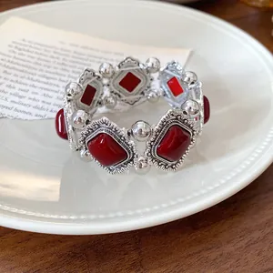 Vintage palace style elastic bracelet with red acrylic stones and silver engraving.