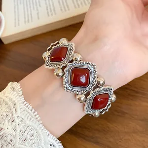 Close-up of a vintage red acrylic stone elastic bracelet with ornate silver frames