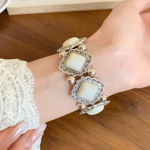 Detailed shot of retro palace style acrylic elastic bracelet on wrist with lace sleeve