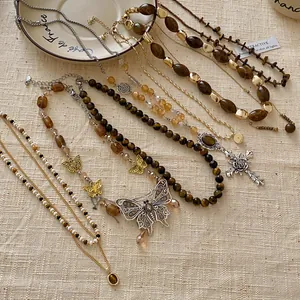 Detailansicht von braunen Tigerauge- und Schmetterlingshalsketten im Maillard-Stil