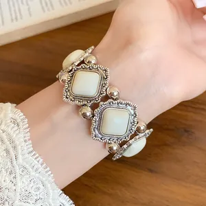 Macro view of vintage court style elastic bracelet with cream acrylic stones on wrist