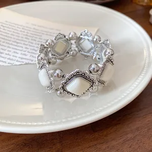 Detail of retro silver bracelet with white rhombus acrylic inserts on white plate