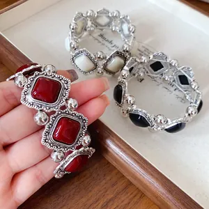 Detailed macro view of vintage palace style elastic bracelets with red and black beads.