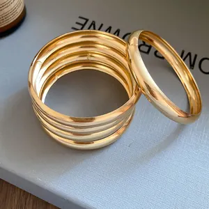 Vue détaillée d'un ensemble de bracelets joncs ronds dorés minimalistes pour femmes