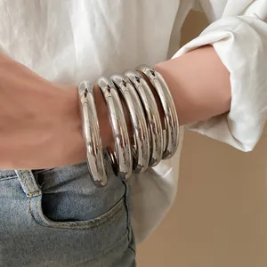 Gros plan montrant la finition argentée polie d'un ensemble de bracelets métalliques