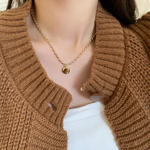 Detailansicht einer goldenen Perlenkette im Vintage-Stil mit einem Tigerauge-Anhänger