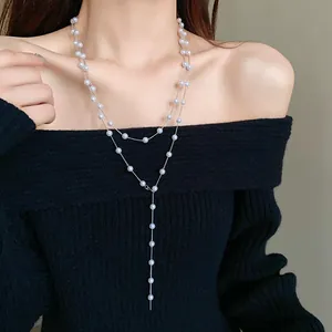 Detailed view of long French style layered artificial pearl necklace worn by model