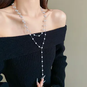 Elegant French style faux pearl long necklace shown as a layered detail on a black sweater.