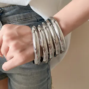 Vue détaillée d'un ensemble de bracelets joncs ronds en métal argenté minimaliste