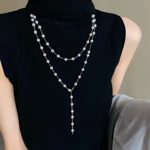 Elegant double-layered artificial pearl long necklace worn over a black turtleneck top