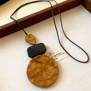Minimalist Zen ethnic necklace with amber marbled resin geometric pendants on black cord