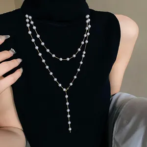 Detail of elegant double-layer faux pearl long necklace sweater chain on black