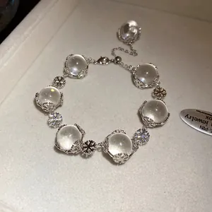 Nahaufnahme eines Glasperlenarmbands mit silbernen Schneeflocken auf einem Display
