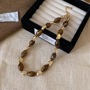 Makroansicht von braunen Tigerauge-Perlen und goldenen Metallakzenten auf Schmuck
