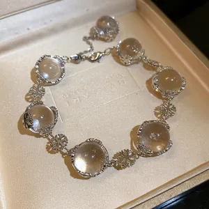 Detailansicht eines Armbands aus Glasperlen mit silbernen Schneeflocken-Anhängern