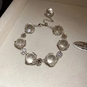 Nahaufnahme eines silbernen Schneeflocken-Armbands mit Glaskugeln auf einem Display
