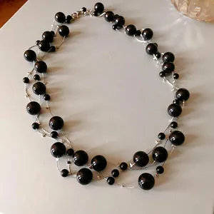 Elegant multi-strand black faux pearl statement necklace with silver-tone chain.